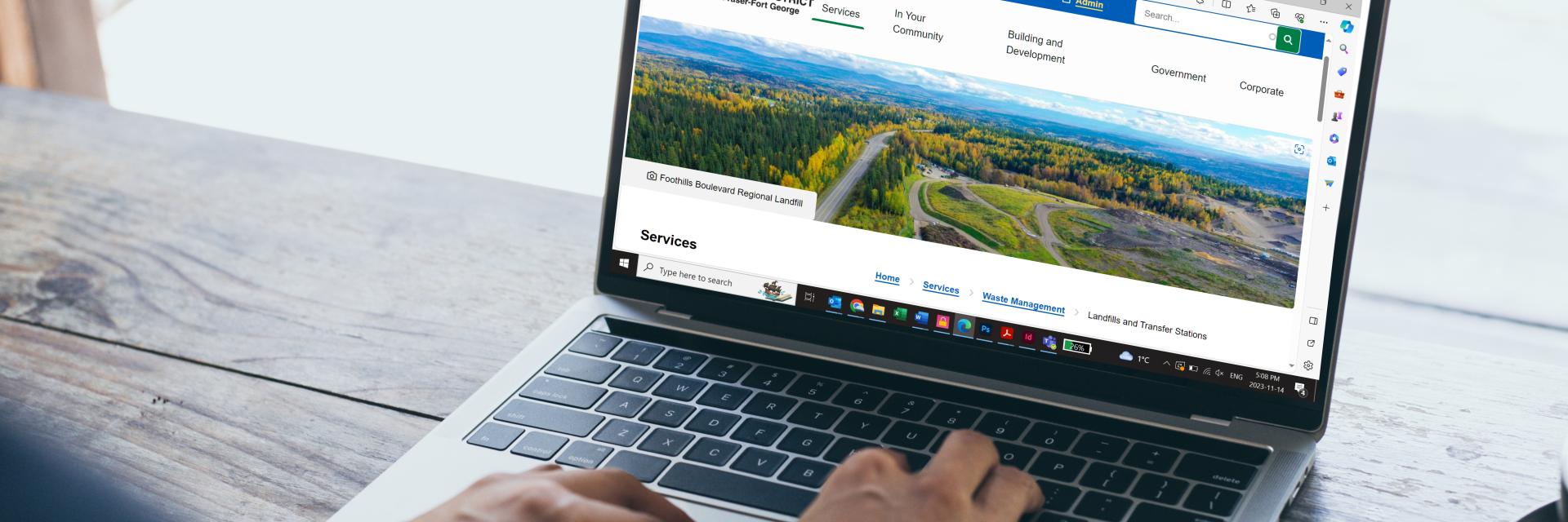 a laptop computer with a picture of a landfill on the screen